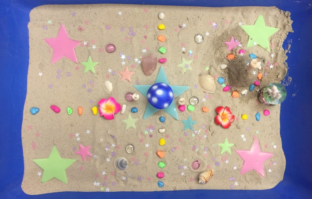 Sensory sand tray with stars, shells, and colourful play