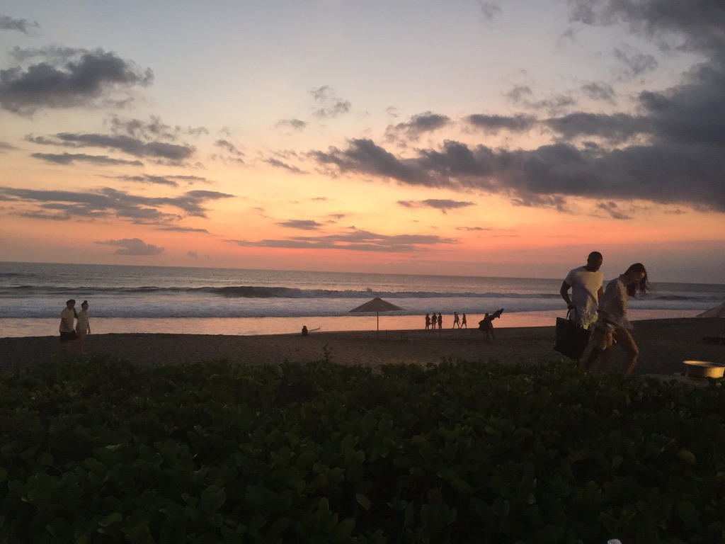 Beach at sunset: sky, ocean, and people on the sand