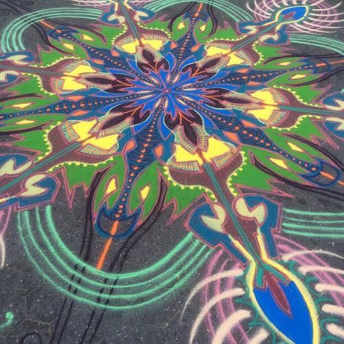 Colourful chalk mandala artwork on pavement